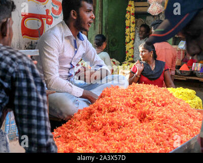 MYSURU (Mysore),KARNATAKA/Inde 13 FÉVRIER 2018:les vendeurs de fleurs et de l'argent change de mains, à l'étal de fleurs,Devaraja,marché,Karnataka Mysore. Banque D'Images