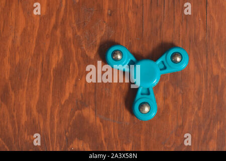 Fidget spinner sur fond isolé dans un bureau en bois à remplir avec copie espace Banque D'Images