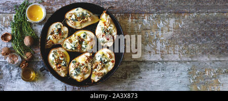 Poires au four avec du fromage bleu, miel et herbes. La cuisine française Entrée au vin. Focus sélectif. Macro. Banque D'Images