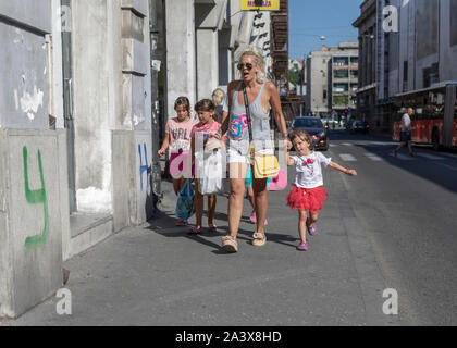 Belgrade, Serbie 13 Août 2019 : scène de rue avec une femme blonde marche dans la rue avec ses trois filles et de hurler sur l'un d'eux Banque D'Images