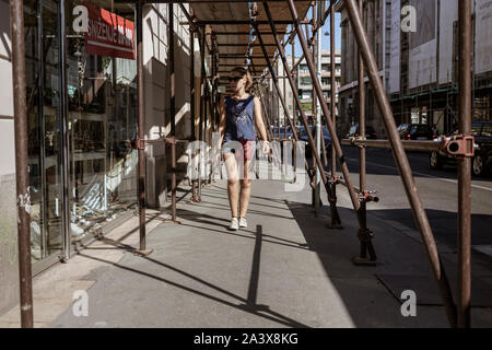 Belgrade, Serbie, May 13, 2019 : une femme marche dans la rue sous les échafaudages placés au-dessus du trottoir Banque D'Images