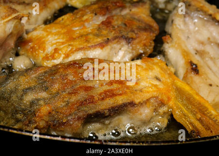 Cuisine faite maison. Les poissons de la rivière Carp, coupé en morceaux, est frit dans la poêle dans l'huile alimentaire. Focus sélectif. Close-up. À l'intérieur. Banque D'Images