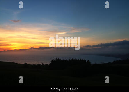 Coucher de soleil sur la baie, sur la péninsule de Kaikoura, île du Sud, Nouvelle-Zélande. La région est une destination écotouristique. Banque D'Images