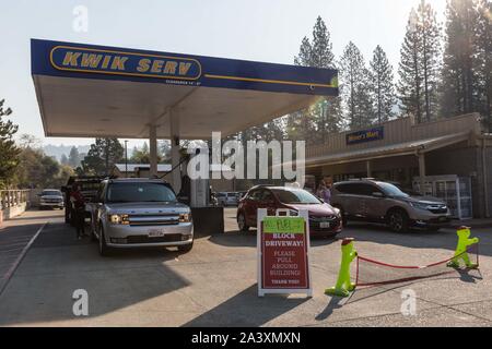 Octobre 10, 2019, Big Oak Flat/Groveland, Californie, États-Unis : Les voitures sont alignées dans le pays bénéficiaire, la gestion familiale, Miner's Mart Kwik Serv gas station jeudi matin dans le Parc National de Yosemite gateway communauté de Big Oak Flat/Groveland. La station est en mesure de fournir aux clients de l'essence parce qu'ils sont en cours d'exécution à partir d'un générateur. De nombreuses entreprises du secteur sont temporairement fermés en raison de l'arrêt de PG&E. Pour protéger la sécurité publique, PG&E a éteint d'électricité environ 34 000 clients dans le comté de Tuolumne en raison de rafales de vent et de sécheresse combinée avec un feu plus ri Banque D'Images