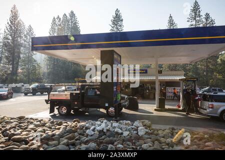 Octobre 10, 2019, Big Oak Flat/Groveland, Californie, États-Unis : Les voitures sont alignées dans le pays bénéficiaire, la gestion familiale, Miner's Mart gas station jeudi matin dans le Parc National de Yosemite gateway communauté de Big Oak Flat/Groveland. La station est en mesure de fournir aux clients de l'essence parce qu'ils sont en cours d'exécution à partir d'un générateur. De nombreuses entreprises du secteur sont temporairement fermés en raison de l'arrêt de PG&E. Pour protéger la sécurité publique, PG&E a éteint d'électricité environ 34 000 clients dans le comté de Tuolumne en raison de rafales de vent et de sécheresse combinée à un plus grand risque d'incendie. Une fois que t Banque D'Images