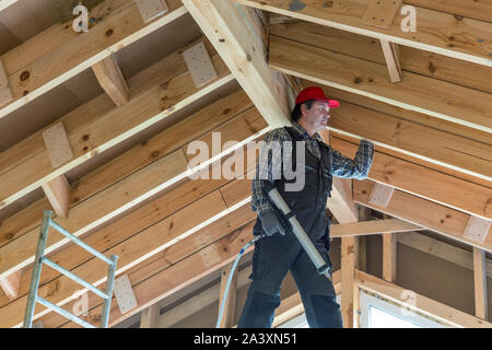 Travailleur de la construction écologique isolant thermique maison à ossature en bois Banque D'Images