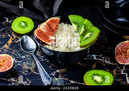 L'avoine délicieux et sains avec des figues, kiwi et la grenade. Petit déjeuner sain. Alimentaire de remise en forme. Une bonne nutrition. Mise à plat. Vue d'en haut. Banque D'Images