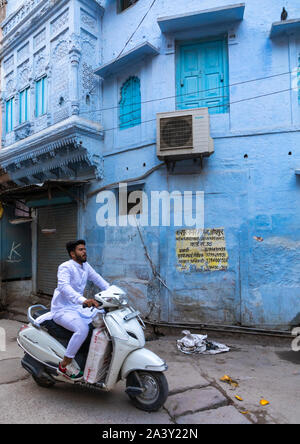 L'homme indien en passant par une vieille maison bleue d'un brahmane en scooter, Rajasthan, Jodhpur, Inde Banque D'Images