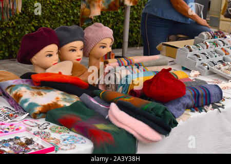 Style Français béret laine chapeaux colorés affichés sur female mannequin heads. Les écharpes, les bijoux et les chapeaux de femme en vente sur une échoppe de marché en Europe. Banque D'Images