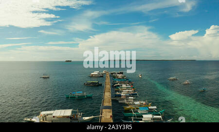 Bateaux de touristes amarré à une longue jetée sur une île tropicale, General Luna, Siargao. Banque D'Images