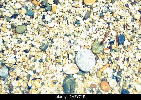 Macro close up de riz grossier moyennes multi-couleur brillant humide grains de sable et gravier texture, vue d'en haut. La plage Kleopatra, Alanya, Antalya, Turquie. Banque D'Images