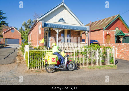 Postman sur cycle moteur de livrer le courrier à un accueil de la fin de l'époque victorienne. Banque D'Images