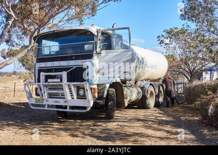 C 1980 Volvo F1023 10 litres 6 cylindres à turbocompresseur camion diesel offrant 13 500 litres/3500 gallons us d'eau domestique à une maison de ferme. Banque D'Images