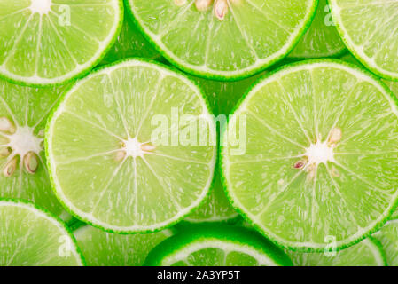 Fond vert avec des agrumes de tranches de lime. Banque D'Images