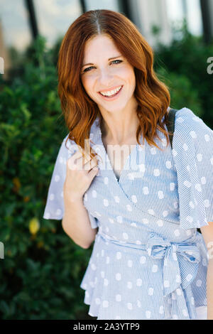Smiling young woman wearing blouse à motifs Banque D'Images