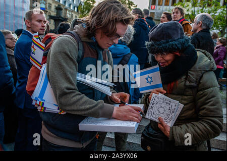 Un homme tenant un drapeau juifs écrit dans une toile en faveur des victimes au cours du rallye.Après deux personnes ont été tuées par un homme armé qui tente d'entrer dans une synagogue de la ville est-allemande de Halle, un rassemblement a lieu à Cologne. Des centaines de personnes se sont réunies autour de la cathédrale de Cologne pour montrer leur soutien en solidarité avec la communauté de Juifs à Halle et partout. Le rassemblement a été organisé par les deux partis politiques de l'Allemagne et Deutsch-Israelische Gesellschaft (DIG), un groupe de travail de l'Association fédérale de la société German-Israeli. Banque D'Images