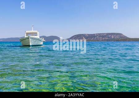 Petit bateau de style traditionnel à flot et amarré dans la mer Méditerranée au large de la côte du Péloponnèse. Banque D'Images