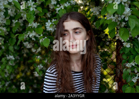 Jeune femme portant des fleurs blanches en bandes Banque D'Images