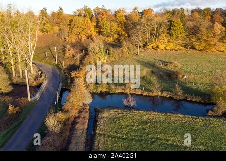 Vue aérienne, DE LA ROUTE ET LA RIVIÈRE LA RISLE DANS LA FORÊT EN AUTOMNE LES COULEURS, RUGLES (27), FRANCE Banque D'Images