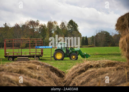 Randonnée en chariot tracteur en attente derrière les rouleaux de foin Banque D'Images