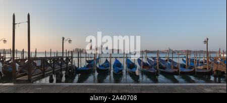 Venise, Italie, en regardant vers la lagune au lever du soleil à partir de la Riva degli Schiavoni, gondoles en premier plan, avec San Giorgio Maggiore dans la distance. Banque D'Images