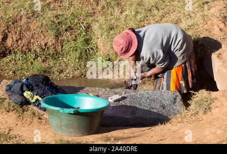Méconnaissable femme faire la lessive dans une rivière, à Madagascar Banque D'Images