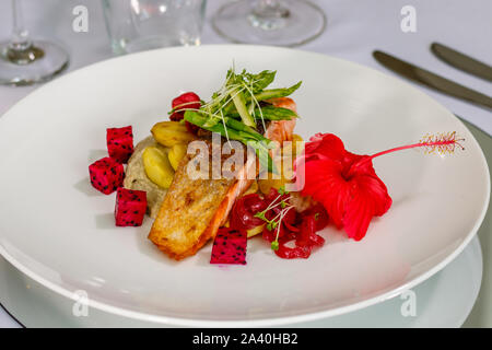 Peau croustillante avec du saumon de l'Atlantique, de pommes de terre rôties asperges sautées et Baba Ghanoush, décorées avec des fèves germées et fruit du dragon. Vue d'en haut Banque D'Images