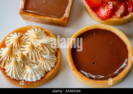 Mini tartelette au citron meringuée et tarte au chocolat noir. Tarte aux fraises tarte au caramel salé et à l'arrière. Vue d'en haut. Banque D'Images