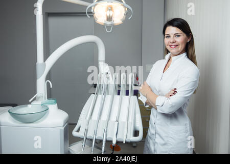 Portrait de femme dentiste .Elle debout dans son bureau de dentiste. Dentiste femelle portant une robe blanche Banque D'Images