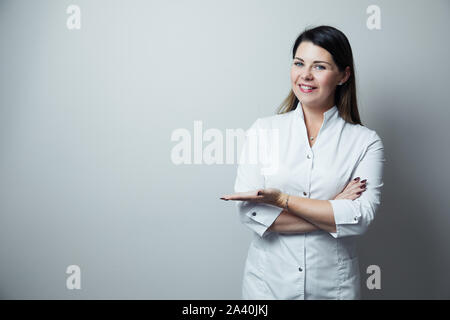 Portrait de femme dentiste .Elle debout dans son bureau de dentiste. Dentiste femelle portant une robe blanche Banque D'Images