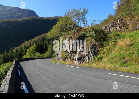 Une route de campagne goudronnée traverse le paysage rural de l'île d'Osterøy, dans le comté de Vestland, en Norvège. Banque D'Images