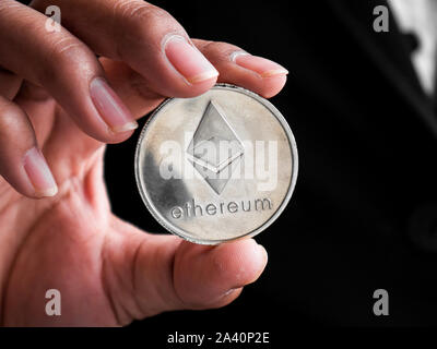 Libre de businesswoman showing ethereum argent médaille. Les investisseurs girl ethereum coin d'extraits dans l'Internet. Banque D'Images