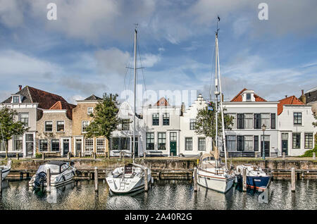 Va, les Pays-Bas, le 9 octobre 2019 : vue avant de huit maisons du canal historique, la brique adjacente et cobblestone quay et voiliers modernes en t Banque D'Images