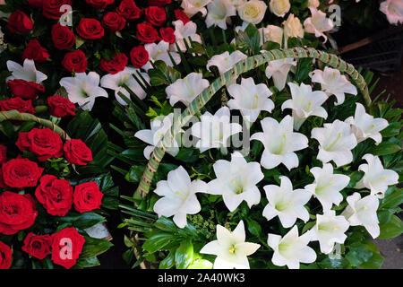 De grands bouquets de roses rouges et de grands paniers avec des lys blancs. Vente de fleurs dans le centre de Tbilissi au marché aux fleurs. Cadeaux romantiques pour lov Banque D'Images