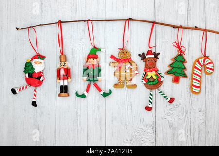 Décorations de Noël suspendu à une branche avec le père Noël, Elf, gingerbread cookie, soldat Casse-noisette, arbre, canne de Noël et le renne de noël. Banque D'Images