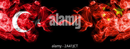 Turquie contre la Chine, le chinois drapeaux de fumée placés côte à côte. La fumée épaisse et soyeuse de couleur de drapeaux turc et en Chine, en chinois Banque D'Images