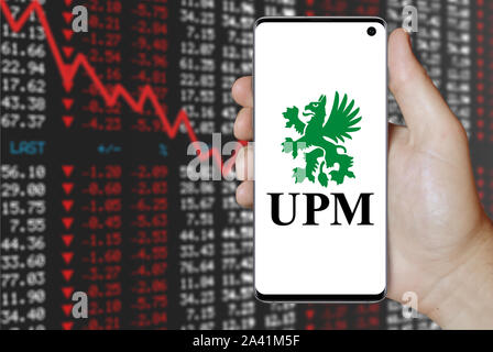 Un homme est titulaire d'un téléphone d'afficher le logo de société UPM-Kymmene énumérés sur OMX Helsinki. Marché des actions négatives. Credit : PIXDUCE Banque D'Images