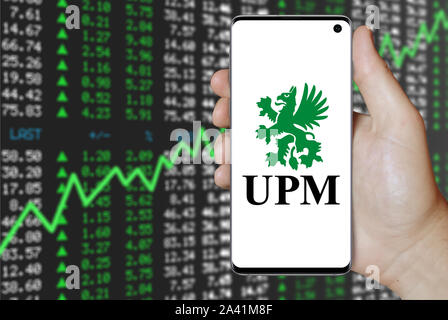 Un homme est titulaire d'un téléphone d'afficher le logo de société UPM-Kymmene énumérés sur OMX Helsinki. Marché des actions positives. Credit : PIXDUCE Banque D'Images