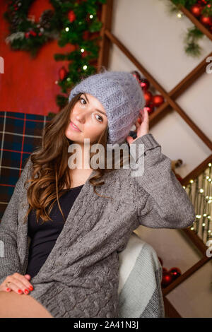 Fille dans une ambiance de Noël. Fille dans une atmosphère de Noël. enveloppé dans une robe pull chaud. jazz. Banque D'Images