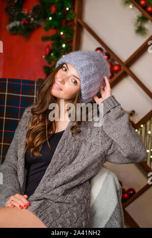 Nouvelle année fille dans un pull. Girl in a New Year's Sweater debout sur un mur à l'arrière-plan. Fille dans un nouveau ans debout sur un chandail et d'or Banque D'Images