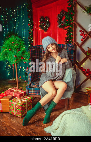 Fille dans un pull et chapeau, sur un fond de Noël. Joyeux Noël et bonne année Adorable happy girl with snowball tenir dans la main. Fermer Banque D'Images