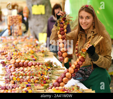 Weimar, Allemagne. Oct 11, 2019. Swantje Pötzschke vend à l'oignon tresses 366Oignons de Weimar. À la vente 500 Zwiebelmarkt et plusieurs étapes dans le centre-ville offrent des divertissements, autour de 60 stands ont été mis en place par les agriculteurs de l'oignon. L'année dernière, le festival a attiré environ 360 000 visiteurs. Crédit : Martin Schutt/dpa-Zentralbild/dpa/Alamy Live News Banque D'Images