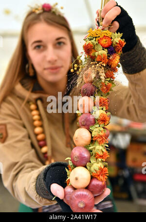 Weimar, Allemagne. Oct 11, 2019. Swantje Pötzschke vend à l'oignon tresses 366Oignons de Weimar. À la vente 500 Zwiebelmarkt et plusieurs étapes dans le centre-ville offrent des divertissements, autour de 60 stands ont été mis en place par les agriculteurs de l'oignon. L'année dernière, le festival a attiré environ 360 000 visiteurs. Crédit : Martin Schutt/dpa-Zentralbild/dpa/Alamy Live News Banque D'Images