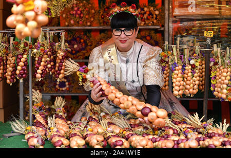 Weimar, Allemagne. Oct 11, 2019. Katrin Hartung, marché de l'oignon 2019 queen, se dresse entre l'oignon tresses sur le 366e marché de l'oignon de Weimar. À la vente 500 Zwiebelmarkt et plusieurs étapes dans le centre-ville offrent des divertissements, autour de 60 stands ont été mis en place par les agriculteurs de l'oignon. L'année dernière, le festival a attiré environ 360 000 visiteurs. Crédit : Martin Schutt/dpa-Zentralbild/dpa/Alamy Live News Banque D'Images