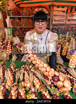 Weimar, Allemagne. Oct 11, 2019. Katrin Hartung, marché de l'oignon 2019 queen, se dresse entre l'oignon tresses sur le 366e marché de l'oignon de Weimar. À la vente 500 Zwiebelmarkt et plusieurs étapes dans le centre-ville offrent des divertissements, autour de 60 stands ont été mis en place par les agriculteurs de l'oignon. L'année dernière, le festival a attiré environ 360 000 visiteurs. Crédit : Martin Schutt/dpa-Zentralbild/dpa/Alamy Live News Banque D'Images