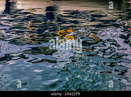 Des vaguelettes sur la surface sombre de la mer Égée . Interaction de bleu foncé, blanc, orange et réflexions. Le point de droit. Banque D'Images