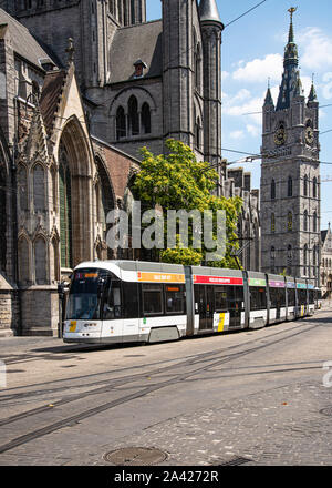 Les transports en tramway publics électriques passent devant l'église St Nicolas et la tour Belfry sur la place Emile Braun à Gand Banque D'Images