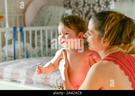 Bébé est heureux dans les bras de Maman. smiling maman. joyeusement ensemble. Les dépenses de mobilier de maison. quand mon père est au travail Banque D'Images