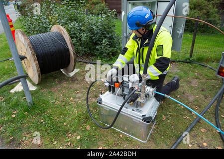 L'homme de l'installation de câble fibre optique pour connexion internet ultra rapide d'une zone résidentielle Banque D'Images