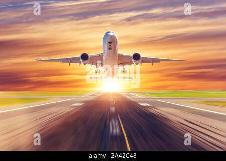 Vue sur le coucher de soleil du soir et l'avion vole jusqu'rapidement dans le ciel Banque D'Images